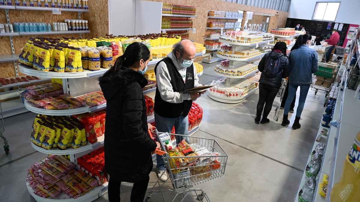 JORDI COTRINA A1-138075264.jpg Barcelona. 27.01.2022. Barcelona. Historia metropolitana en El Prat de Llobregat. Josep Agustí ayuda con la lista de la compra frente a las estanterías en ‘La Botiga’, proyecto de innovación social donde las personas beneficiarias se implican en la cogestión del espacio. Fotografía de Jordi Cotrina