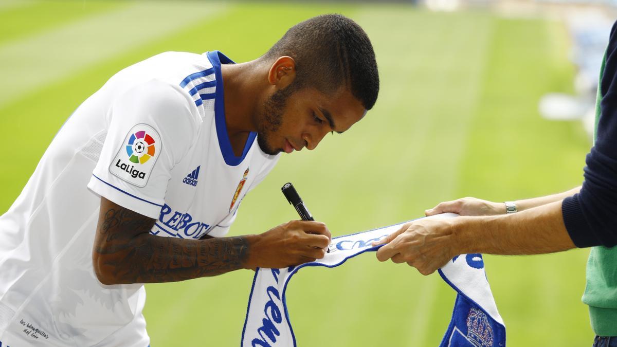César Yanis firma una bufanda en su presentación con el Zaragoza.