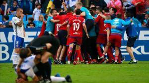 Los jugadores del Numancia celebran la victoria en La Romareda ante los desolados jugadores del Zaragoza.