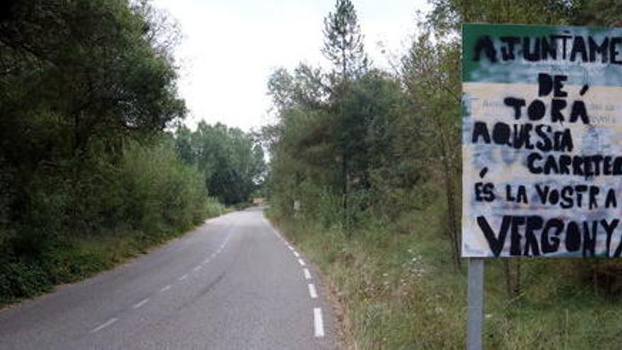 Un cartell on es llegeix &#039;Ajuntament de Torà, aquesta carretera és la vostra vergonya&#039;.