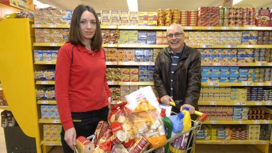 Lorena Suárez, encargada de Supermercados Alimerka, hace entrega de su premio de 100 euros a Luis Alberto Cienfuegos, de Mieres.  | fernando geijo