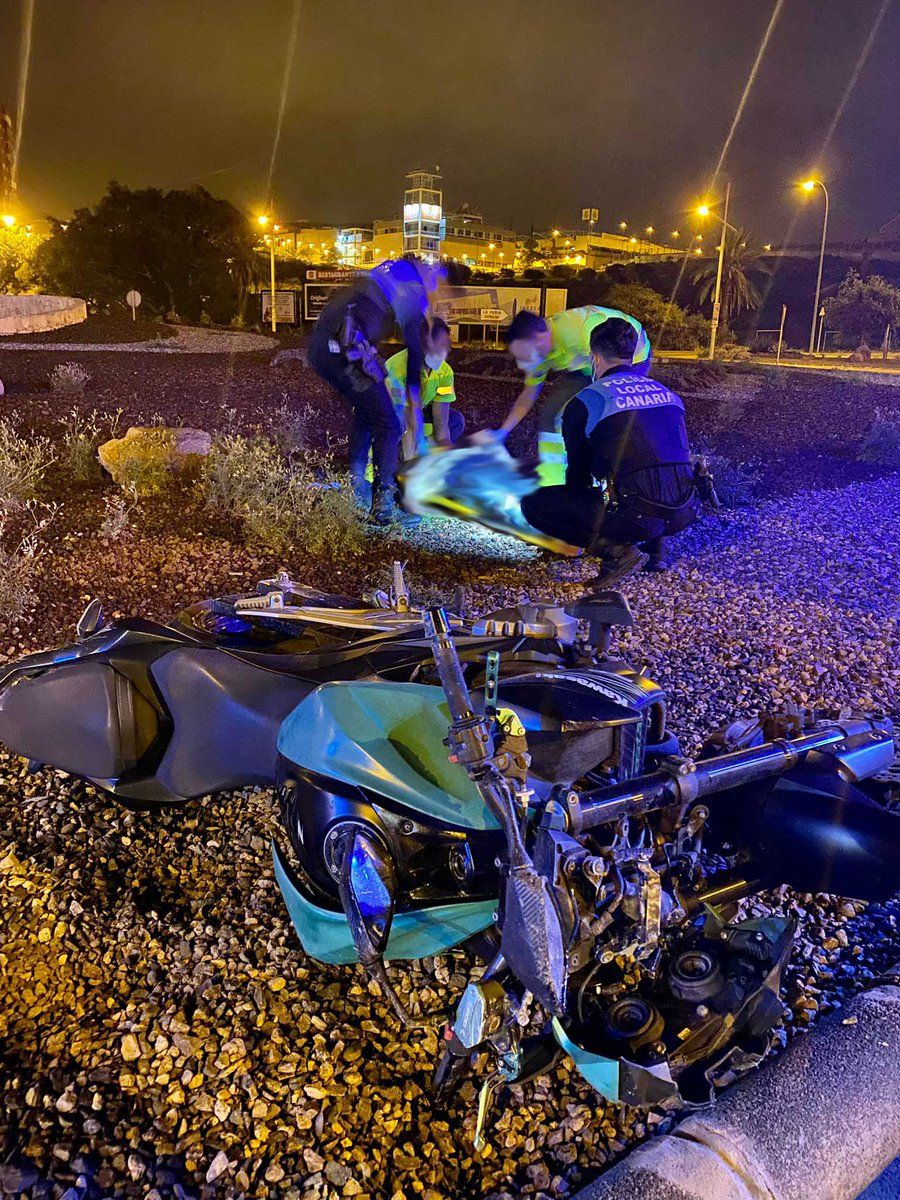 En primer plano, la moto accidentada anoche en la rotonda del Vigía. Detrás, los policías atienden al herido.
