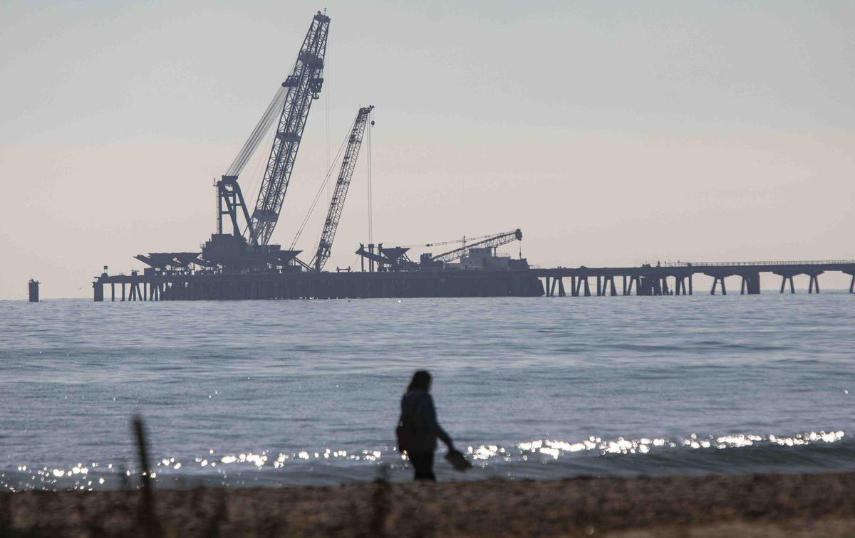 Vecinos del Port de Sagunt observan desde la playa la retirada de las tolvas del Pantalán