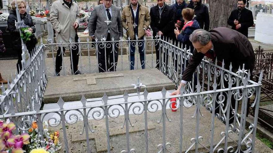 Dionisio Alba coloca una vela en la sepultura de Antonio Alonso, antiguo hermano mayor.