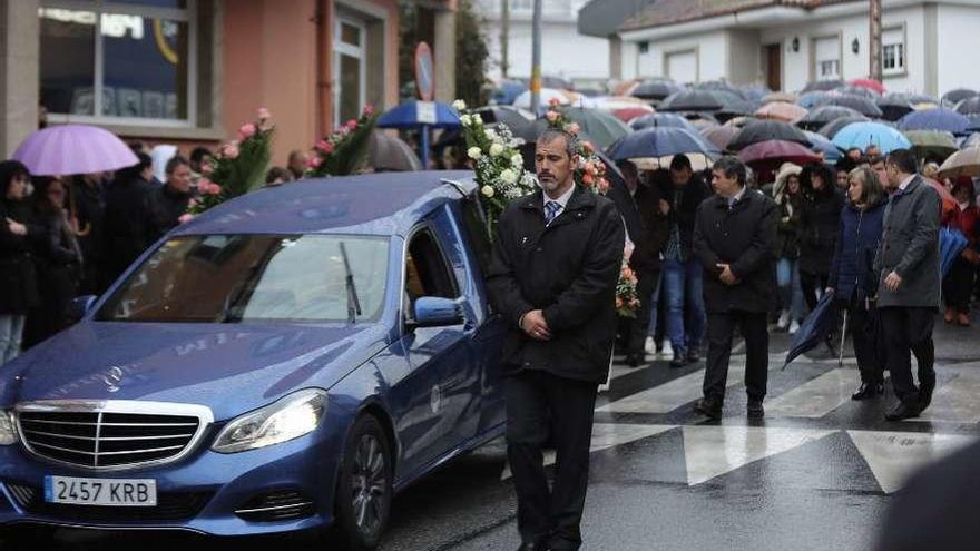 Cientos de personas caminan tres el coche fúnebre en O Grove. // Muñiz