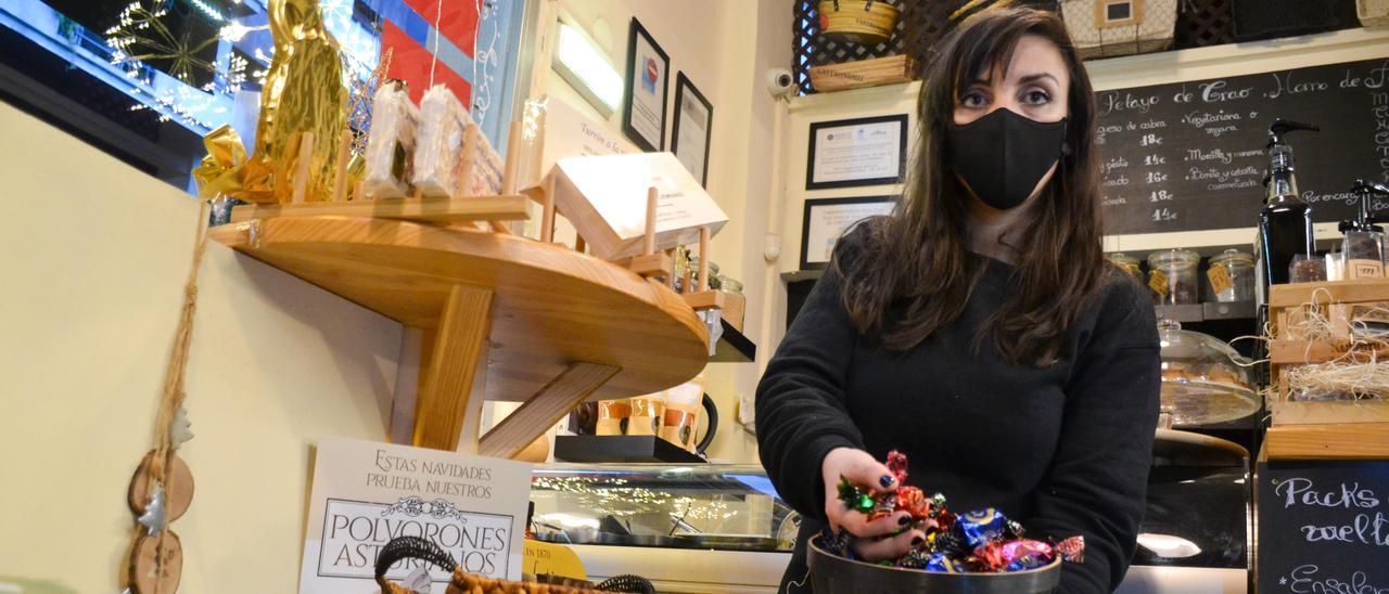 Sofía González Vara, propietaria de Eliso Alimentación, en Oviedo, muestra algunos de los dulces navideños que vende en su establecimiento.