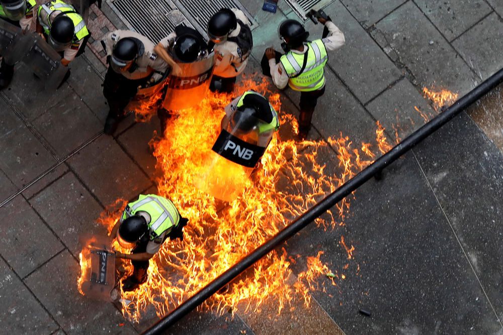 Riot security forces members catch fire during ...