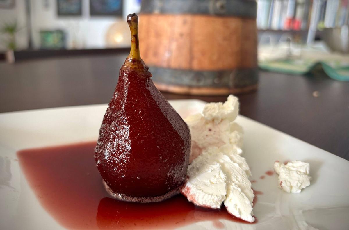 Pera al vino servida con nata.
