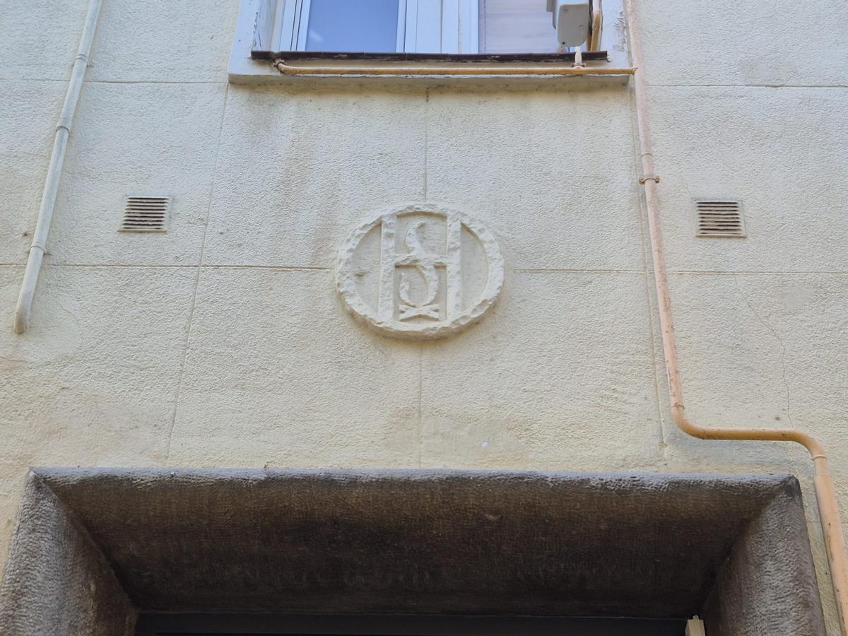El emblema de la Obra Sindical del Hogar, existente durante el franquismo, en un bloque del distrito de Sant Martí, en Barcelona.