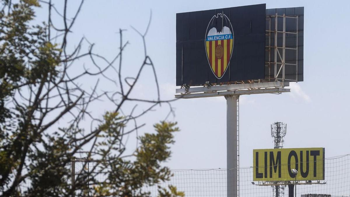 El cartel publicitario de protesta, junto al escudo del Valencia en la ciudad deportiva. | J.M. LÓPEZ