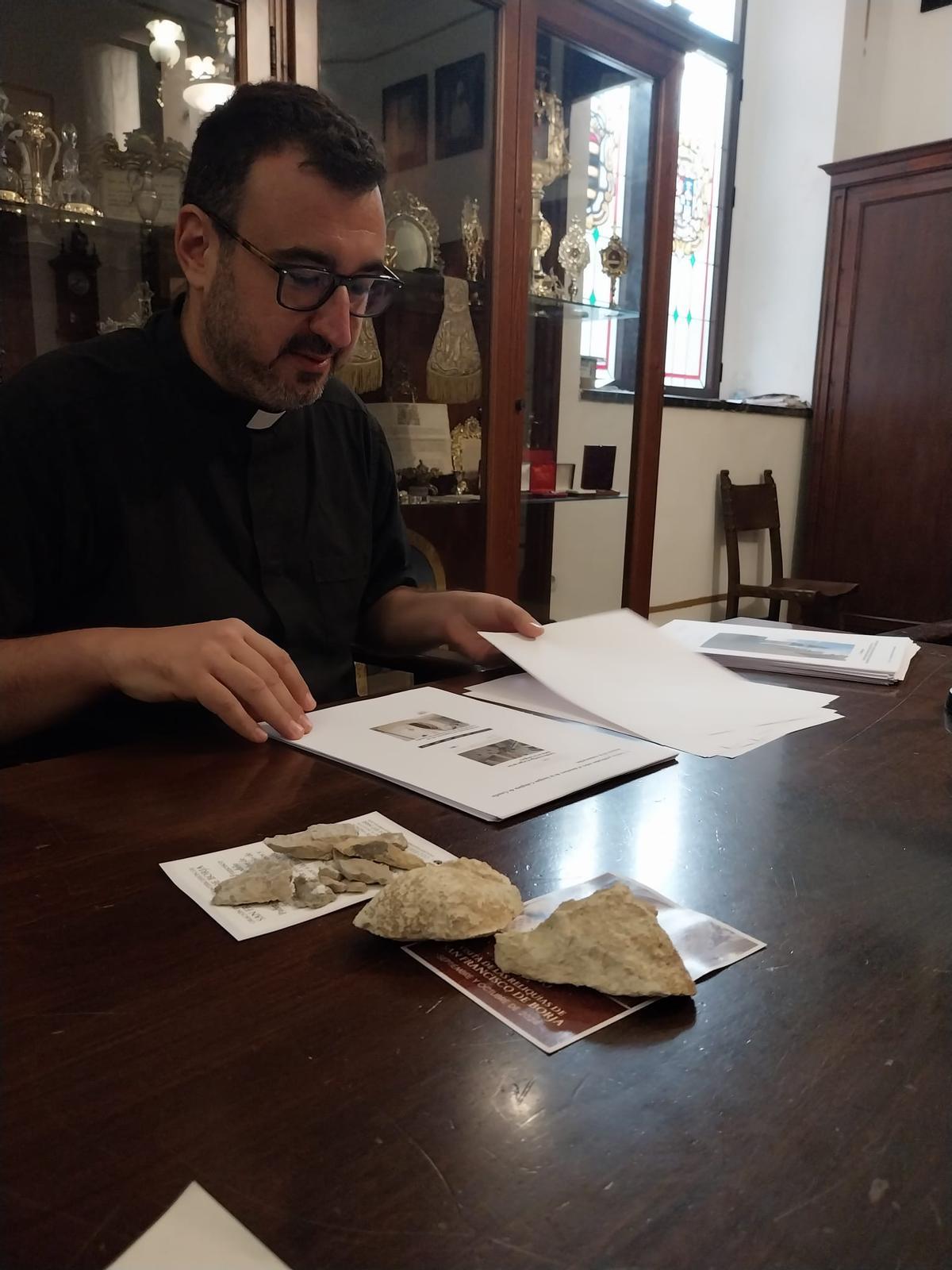 El sacerdote Francisco Llorens, ante piedras caídas del techo de la Colegiata.