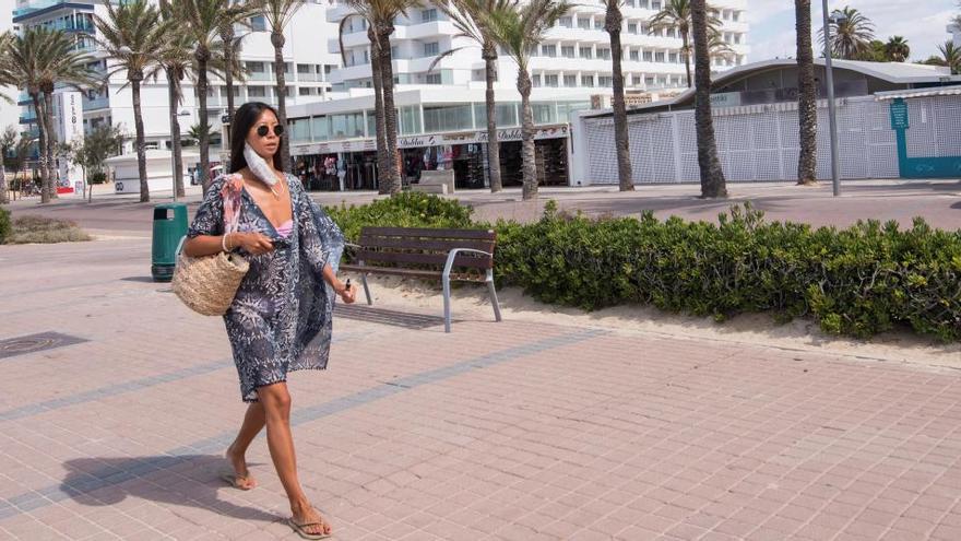 Una mujer camina por el paseo de la playa de Palma