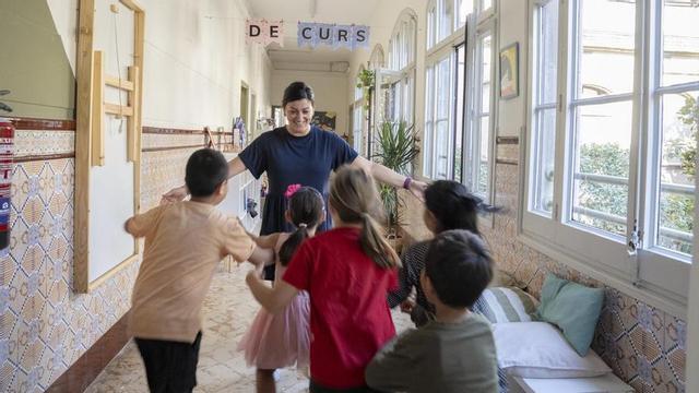 Una professora rep els alumnes el primer dia del curs 2025-2026 en una escola de Barcelona. | FERRAN NADEU