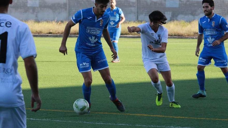 Chemi conduce el balón delante de Guilda.