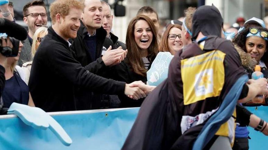 Los duques de Cambridge y el príncipe Enrique animan a un corredor.