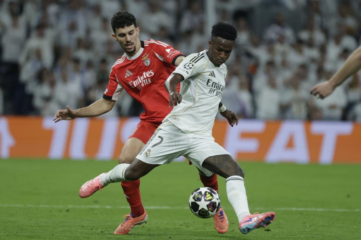 Vinicius se lleva el balón ante el defensor del Benfica.