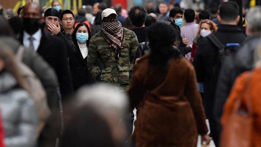 Ciudadanos con mascarilla en una céntrica calle de Londres.