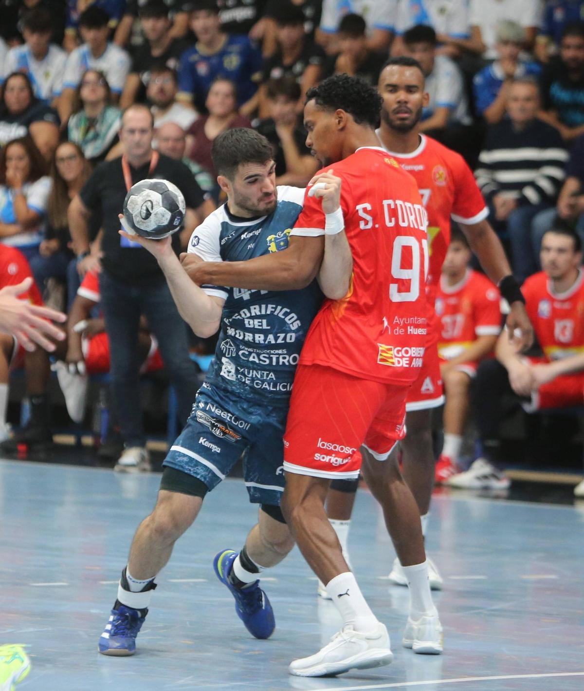 Santi es agarrado por Samuel Cordies en el duelo entre el Cangas y el Huesca.