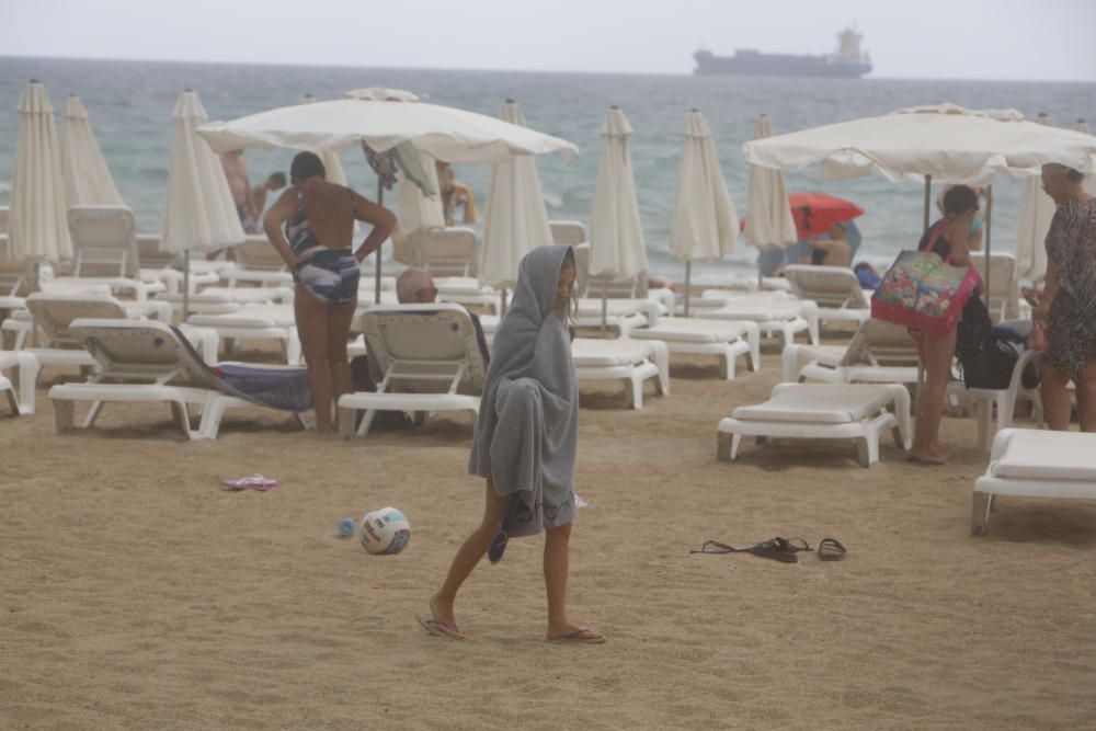 La lluvia sorprende a los bañistas en el Postiguet