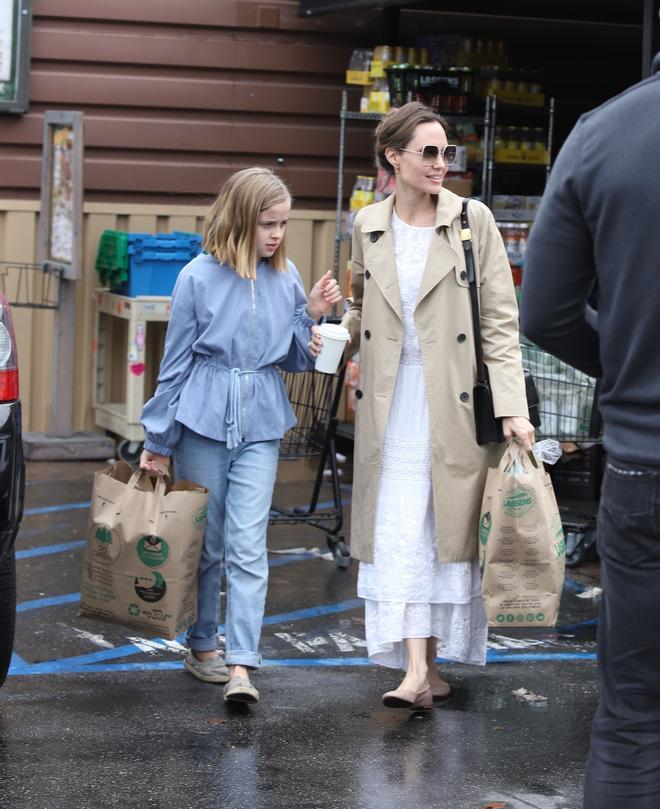 Angelina Jolie con vestido blanco y trench junto a su hija Vivienne