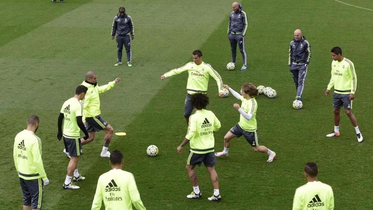 Zidane observa los movimientos de sus jugadores en el entrenamiento de este viernes en Valdebebas