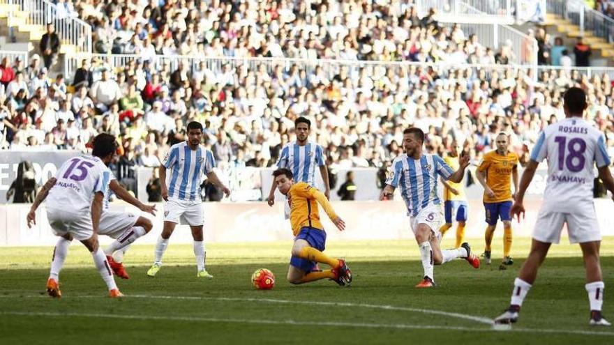 Messi intenta golpear el balón al borde del área del Málaga rodeado por media docena de jugadores rivales. // Jon Nazca