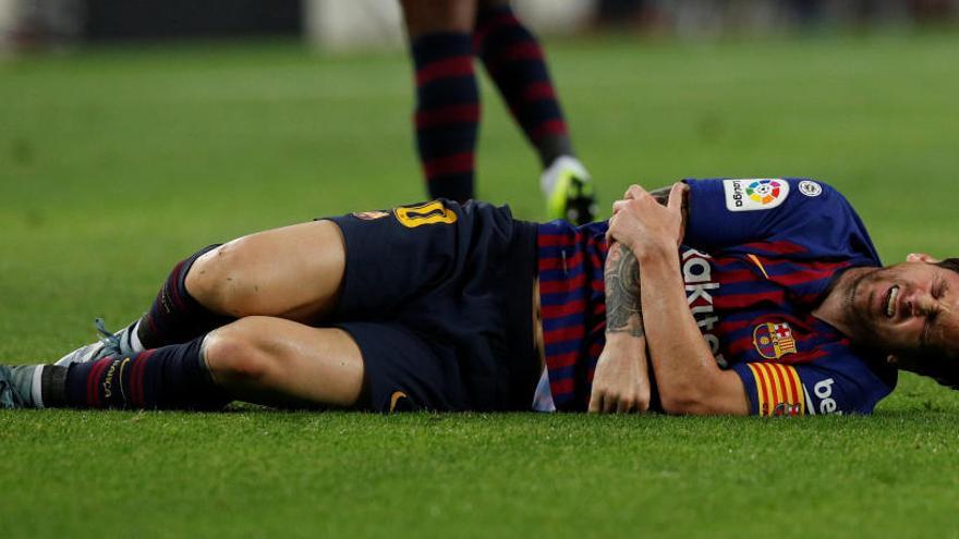 Lionel Messi se duele de su brazo en el césped.