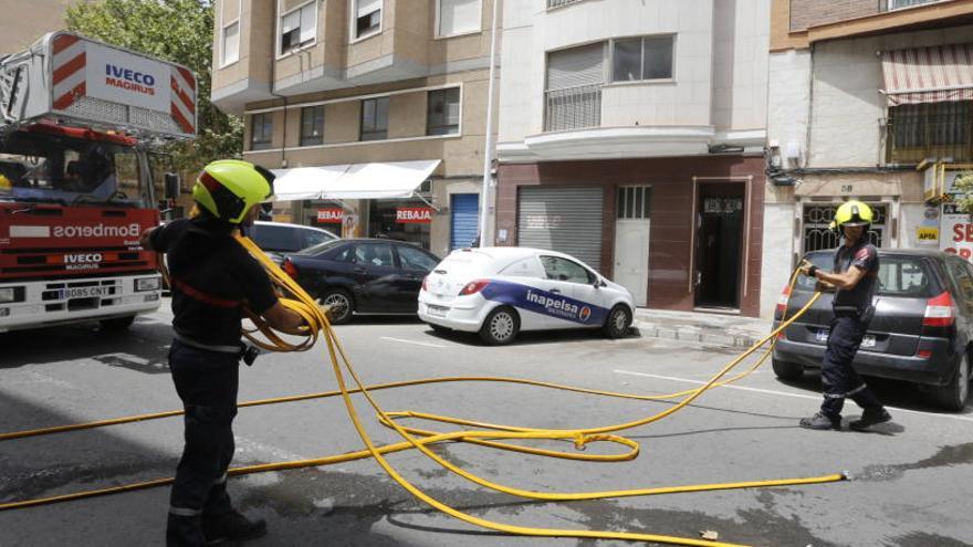 Los bomberos, sofocando el fuego en la vivienda