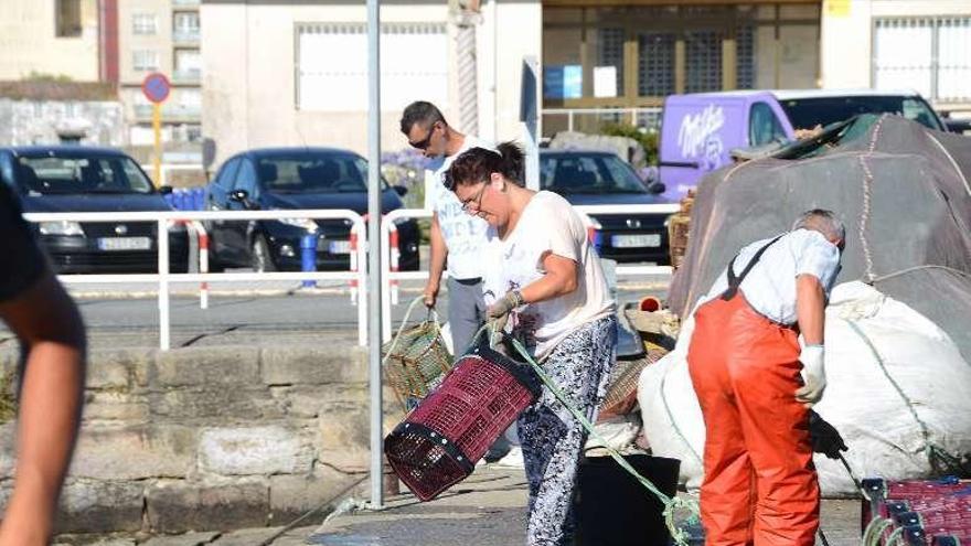 Una mujer prepara una nasa para bajarla a un barco de Bueu. // G.N.