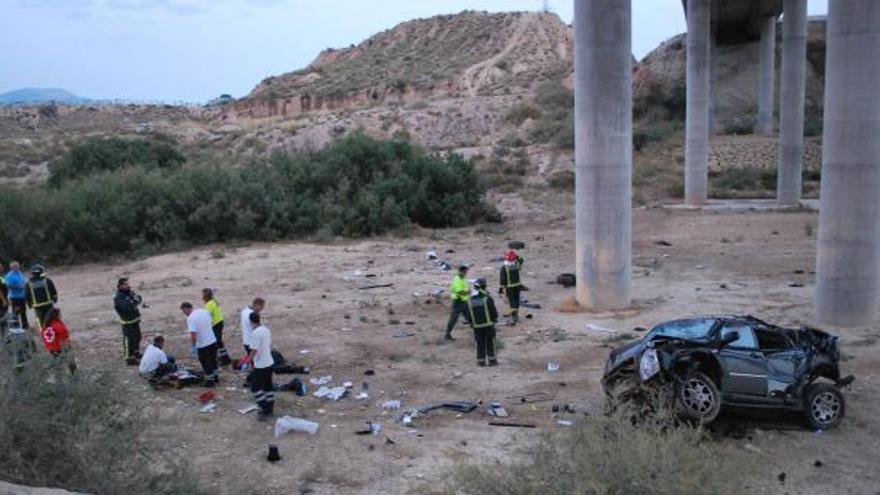 Los equipos de emergencias atienden al herido junto a los restos del coche, que quedó destrozado.