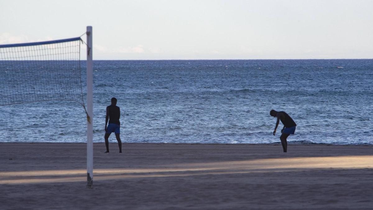 Dos migrantes acogidos por Cruz Roja en una playa de Gandía.