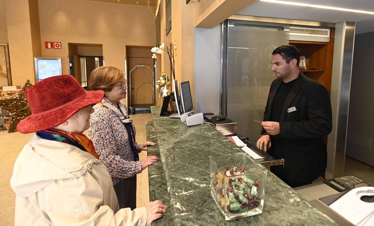 Dos mujeres realizan el ‘check-in’ en un hotel del centro de Vigo.