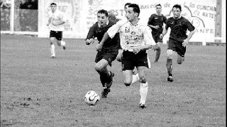 Jimmy, perseguido por el avilesino Mimi, conduciendo el balón en el partido de la pasada temporada en Los Tarronales.