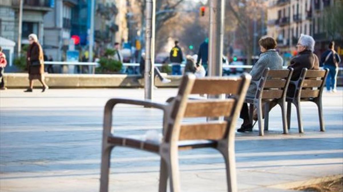 Dos mujeres jubiladas descansan en unos bancos en Barcelona.