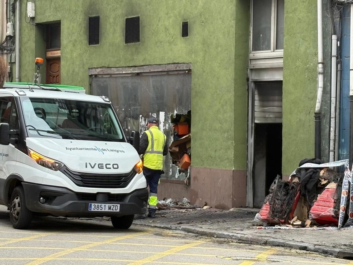 Operarios del Ayuntamiento de Langreo retirando los restos del incendio en el que falleció un comerciante chino en La Felguera