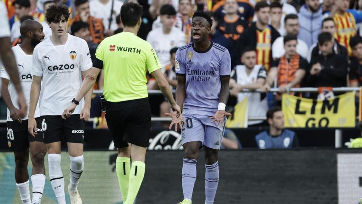 El árbitro de Burgos Bengoetxea (2d) habla con el delantero brasileño del Real Madrid Vinícius Júnior (d) durante el partido correspondiente a la jornada 35 de LaLiga Santander que disputaron Valencia CF y Real Madrid este domingo en Mestalla (Valencia).