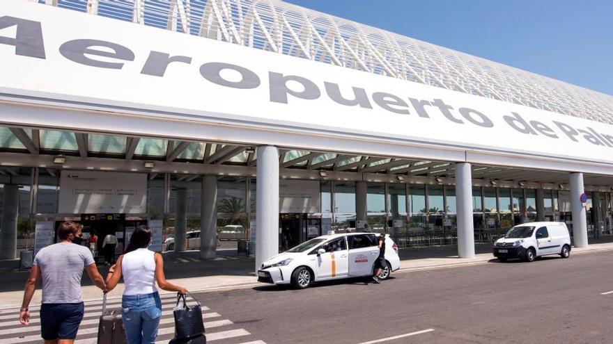 Varios turistas se dirigen a la terminal de salida del aeropuerto de Palma.