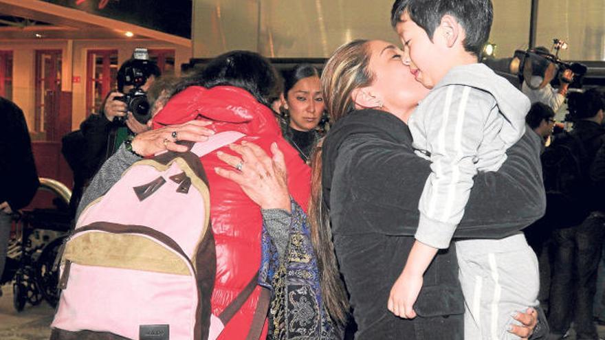 Familiares reciben a una mujer y a su hijo, procedentes de Japón, en el aeropuerto de México.