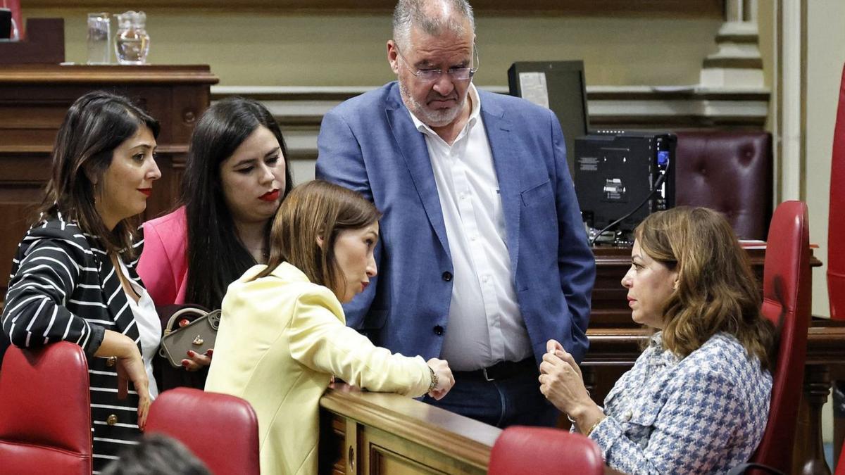 La presidenta de los socialistas del Parlamento habla con varios diputados de su bancada antes del Pleno.