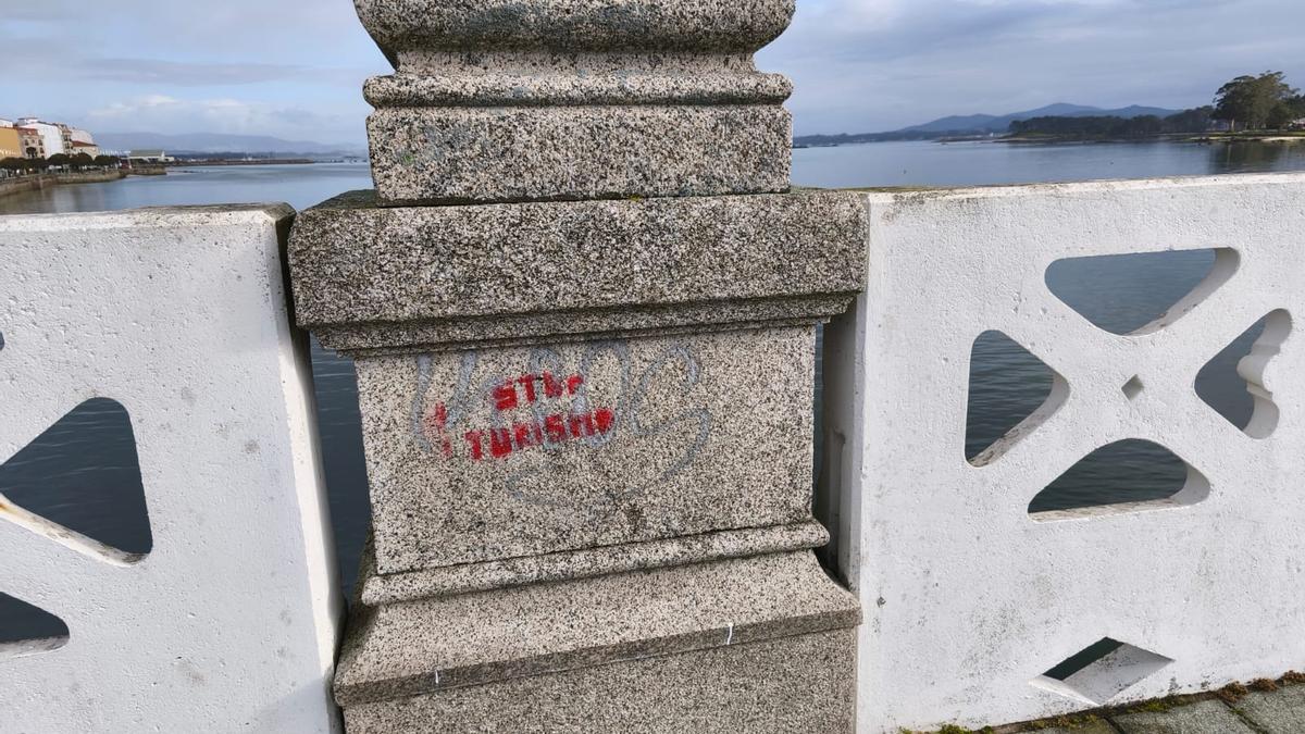 Una pintada contra el turismo en el puente de A Toxa.
