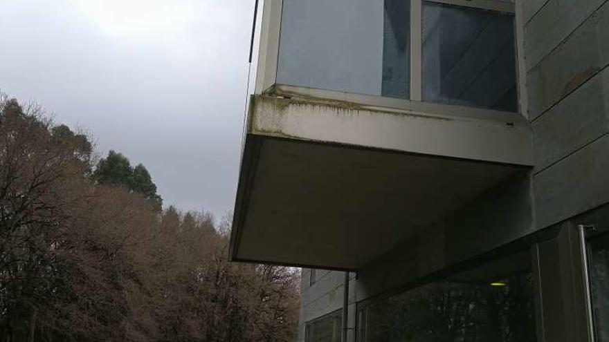 Arriba, varias planchas desprendidas de la fachada. Abajo, el agua ya dañó la carpintería de una ventana del centro de salud.