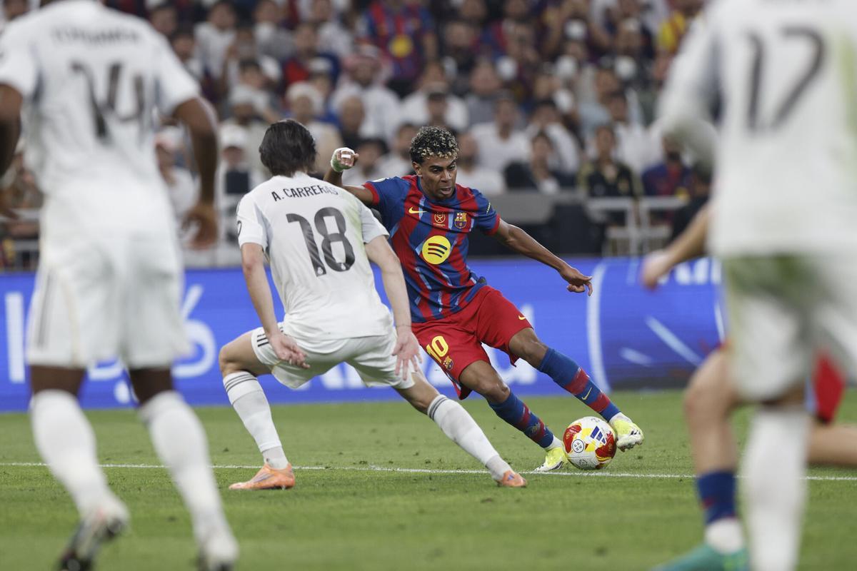 YEDA (ARABIA SAUDÍ), 11/01/2026.- El delantero del FC Barcelona Lamine Yamal (d) disputa un balón con el defensa del Real Madrid Álvaro Carreras (c) durante la final de la Supercopa de España entre el FC Barcelona y el Real Madrid, este domingo en el estadio Ciudad Deportiva del Rey Abdalá de Yeda (Arabia Saudí). EFE/ Kai Försterling