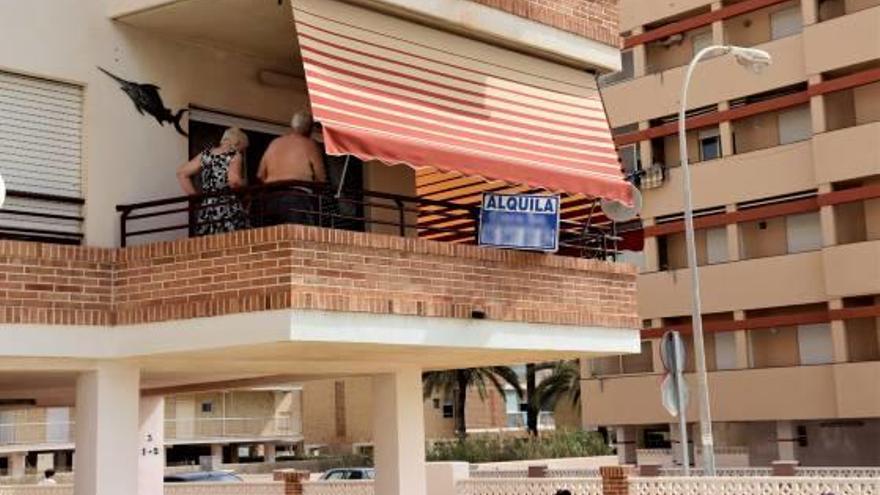 Una familia en el balcón de un apartamento junto a Playa Lisa que alquilaron desde una inmobiliaria de la localidad