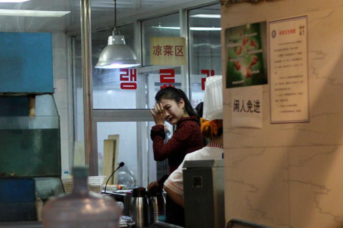 Una cambrera plora després de conèixer la notícia de la mort del líder nord-coreà Kim Jong-il, en un restaurant de Pequín (Xina).