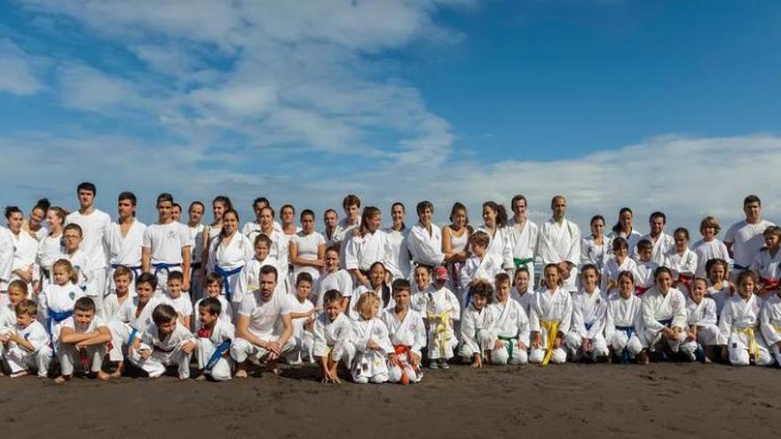 Los karatecas participantes en el torneo benéfico posan en la playa de Los Quebrantos.