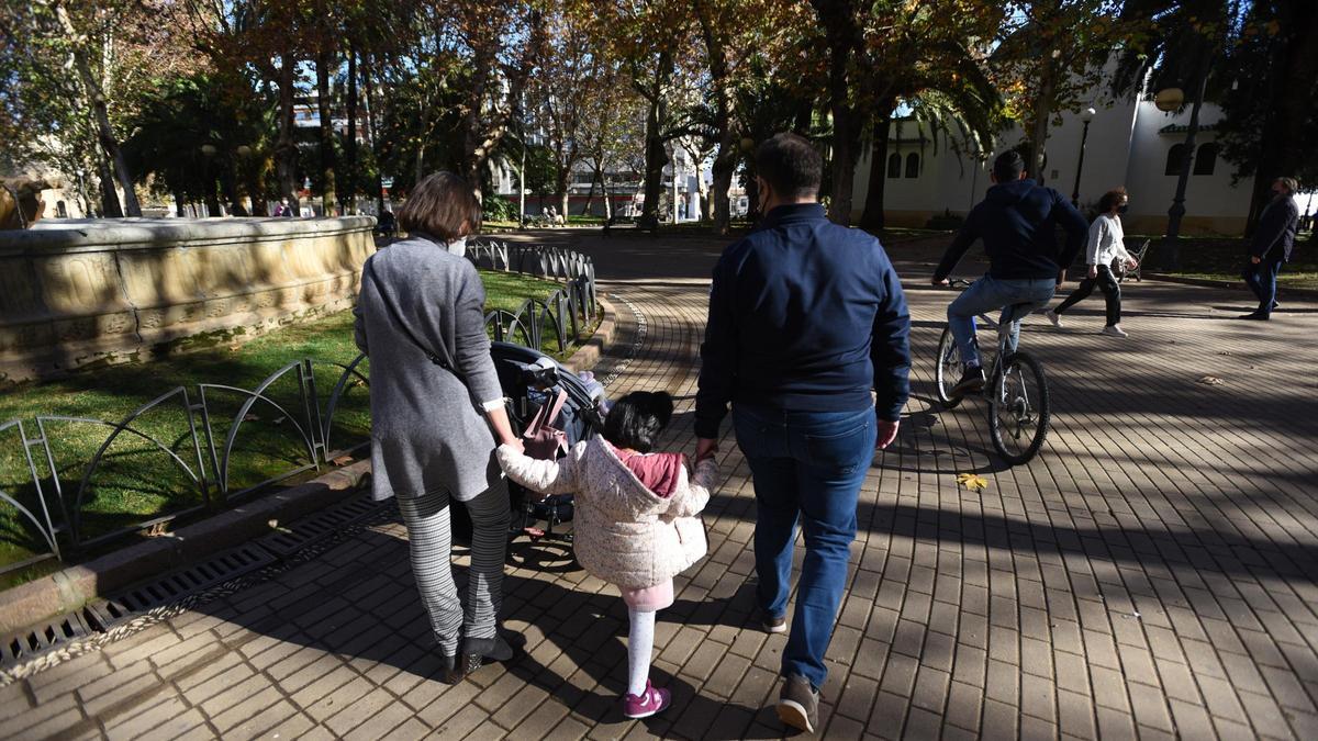 Unos padres de adopción pasean con sus hijas.