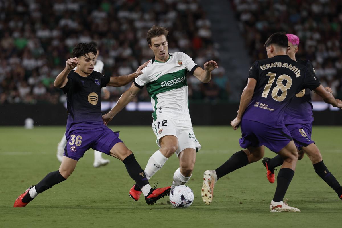 ELCHE (ALICANTE), 23/08/2026.- El defensa austriaco del Elche, David Affengruber (c) pelea un balón con el defensa del Barcelona Gerard Martín (d) durante el partido de LaLiga de fútbol que Elche CF y FC Barcelona disputan este domingo en el estadio Martínez Valero. EFEManuel Bruque