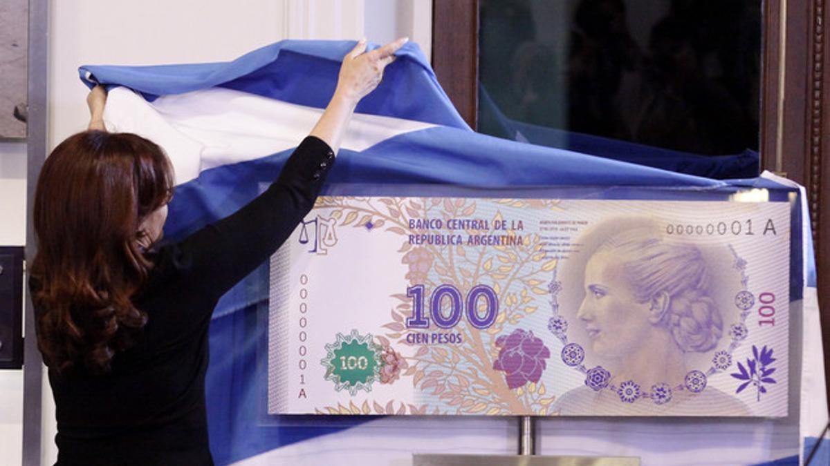 La presidenta argentina, Cristina Fernández de Kirchner, descubre una imagen del nuevo billete de 100 pesos, con la imagen de Eva Duarte de Perón, el miércoles, en Buenos Aires.