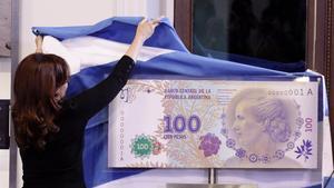 La presidenta Cristina Fernández de Kirchner descubre una imagen del nuevo billete de 100 pesos, con la imagen de Eva Duarte de Perón, en julio pasado.