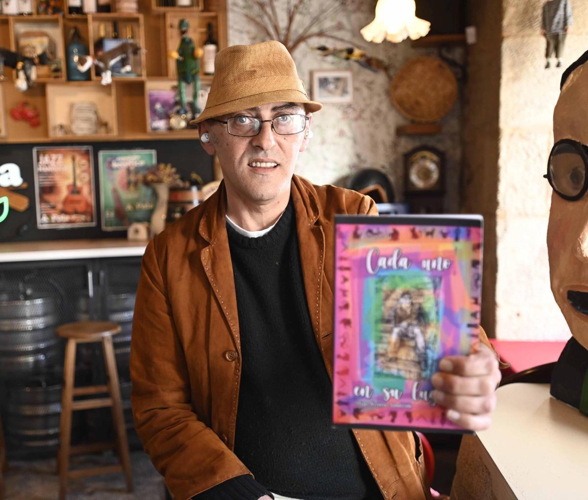 Íñigo Álvarez, en A Póla, negocio del Paseo de Alfonso, con su obra en la mano.